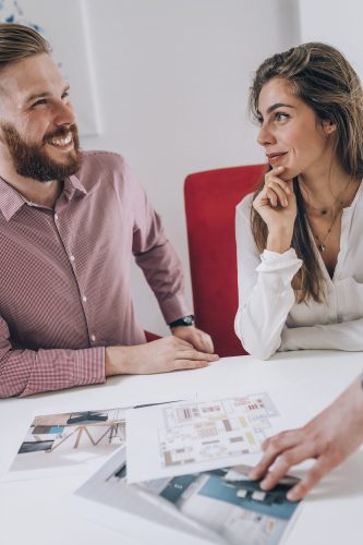 Young smiling couple in real estate agency office